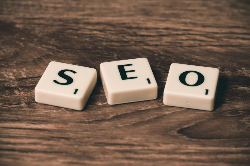 SEO spelled out with Scrabble tiles on a wooden background.